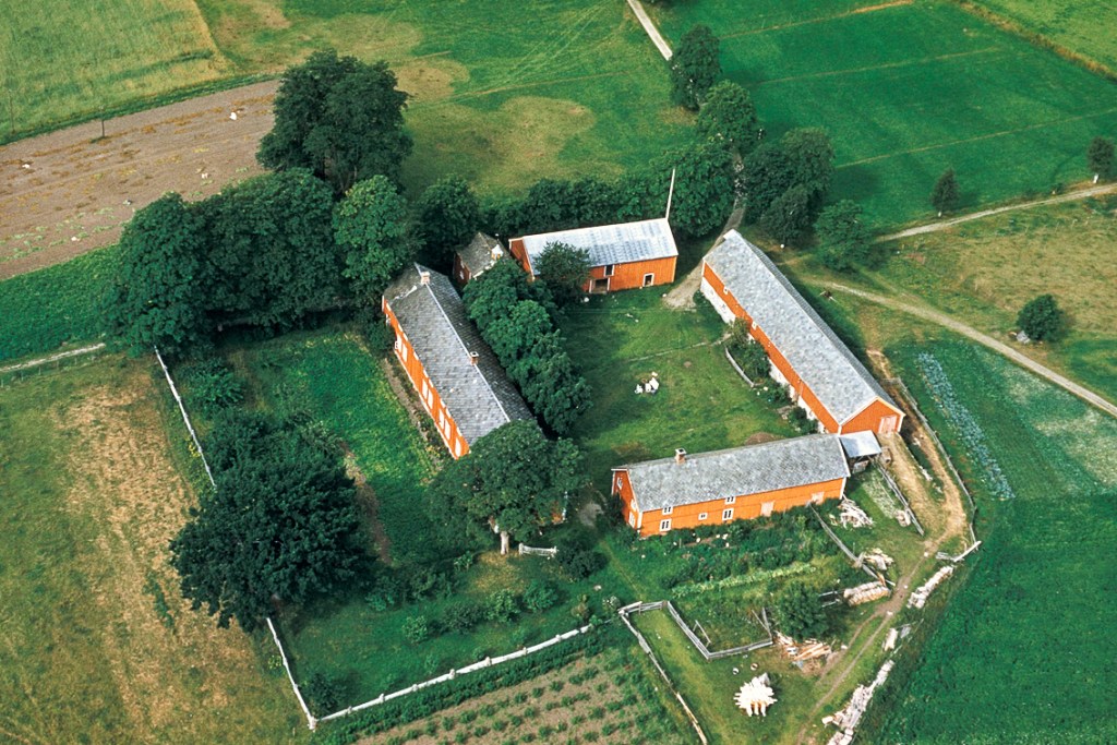 Aerial view of a traditional farming complex surrounded by lush greenery and agricultural fields.